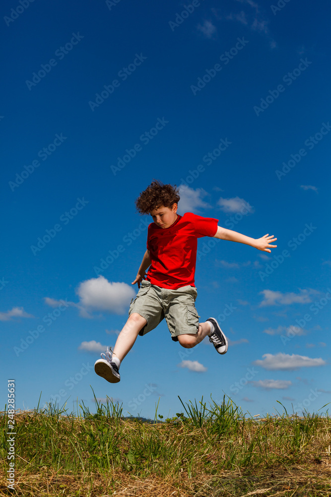Boy jumping, running against blue sky Boy jumping, running against blue sky