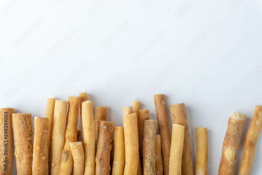 Natural toothbrush Miswak (Kayu Sugi) on white background with selective focus. It is a teeth cleaning twig made from the Salvadora persica tree and also know as miswaak, siwak, Sugi or sewak