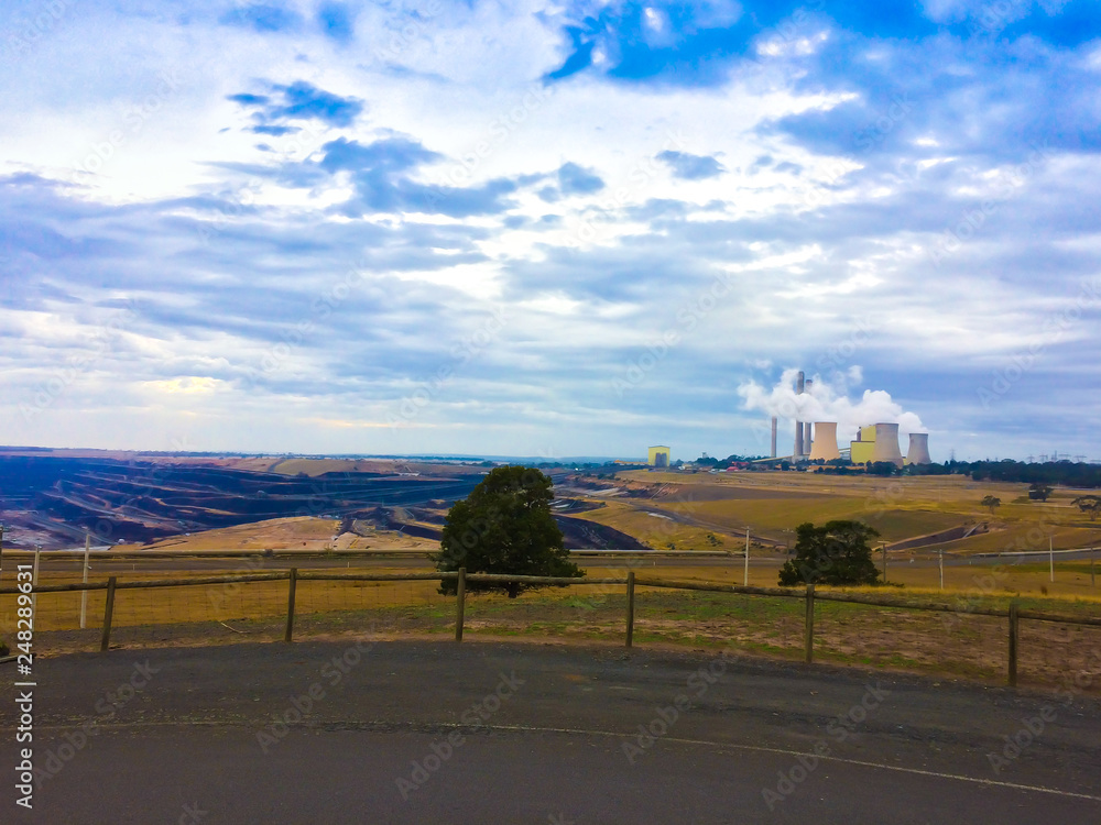 Coal power plant generator emitting gas to the air ozone atmosphere in the middle of the desert dry land near small city Coal power plant generator emitting gas to the air ozone atmosphere in the middle of the desert dry land near small city