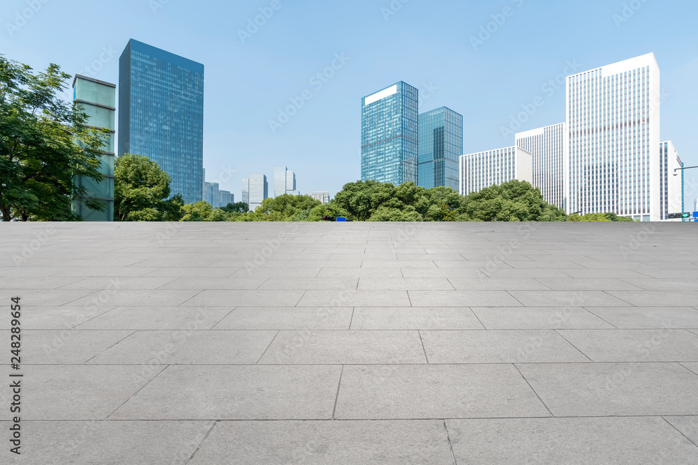 Empty Plaza floor tiles and the skyline of modern urban buildings in Hangzhou..