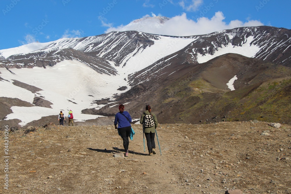 Hikers are on the route. Avachinsky volcano is visible in the background.