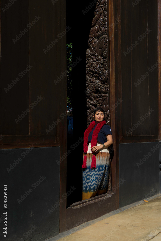 femme et porte sculptée au black temple de Chaing raï