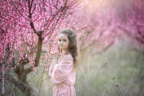 Beautiful young woman in pinkstylish garden dress blooming sakura © ElenaBatkova