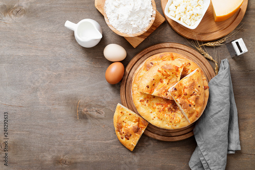 Freshly baked khachapuri with cheese on a wooden table.