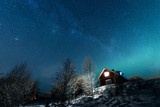 The northern lights Aurora Borealis and Milky Way at Kuukiuru village lake in Lapland, Finland.