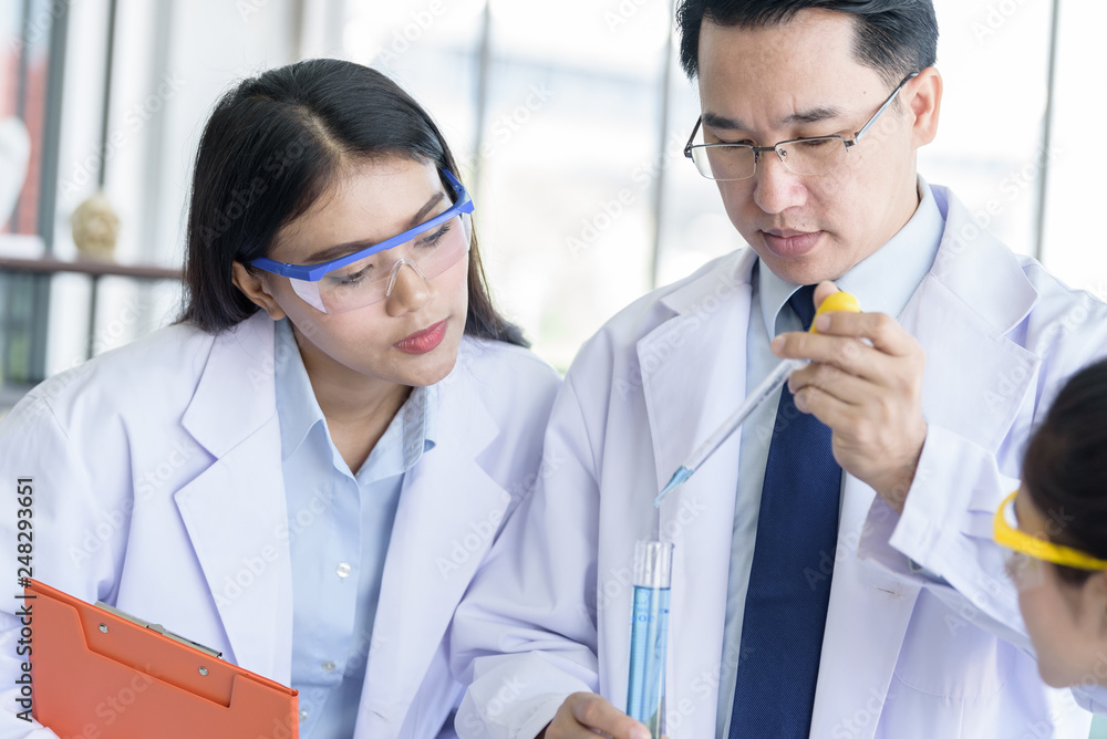Asian yound student scientist researching and learning with senior scientist have teaching background in a laboratory. Asian yound student scientist researching and learning with senior scientist have teaching background in a laboratory.