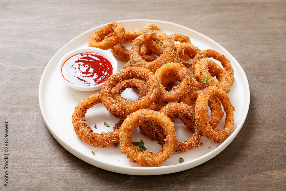 Delicious golden battered, breaded and deep fried crispy onion rings with ketchup.