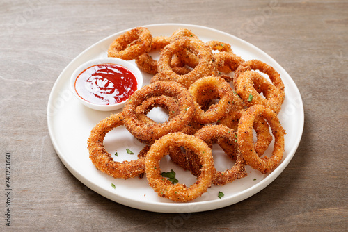 Delicious golden battered, breaded and deep fried crispy onion rings with ketchup.