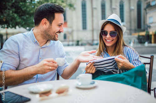 Beautiful loving couple sitting in a cafe enjoying in coffee and conversation after shopping