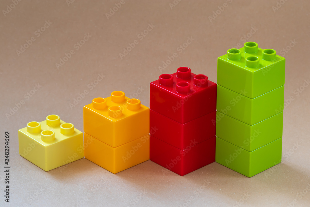 Fototapeta premium Growing bar chart from color toy blocks on beige background.