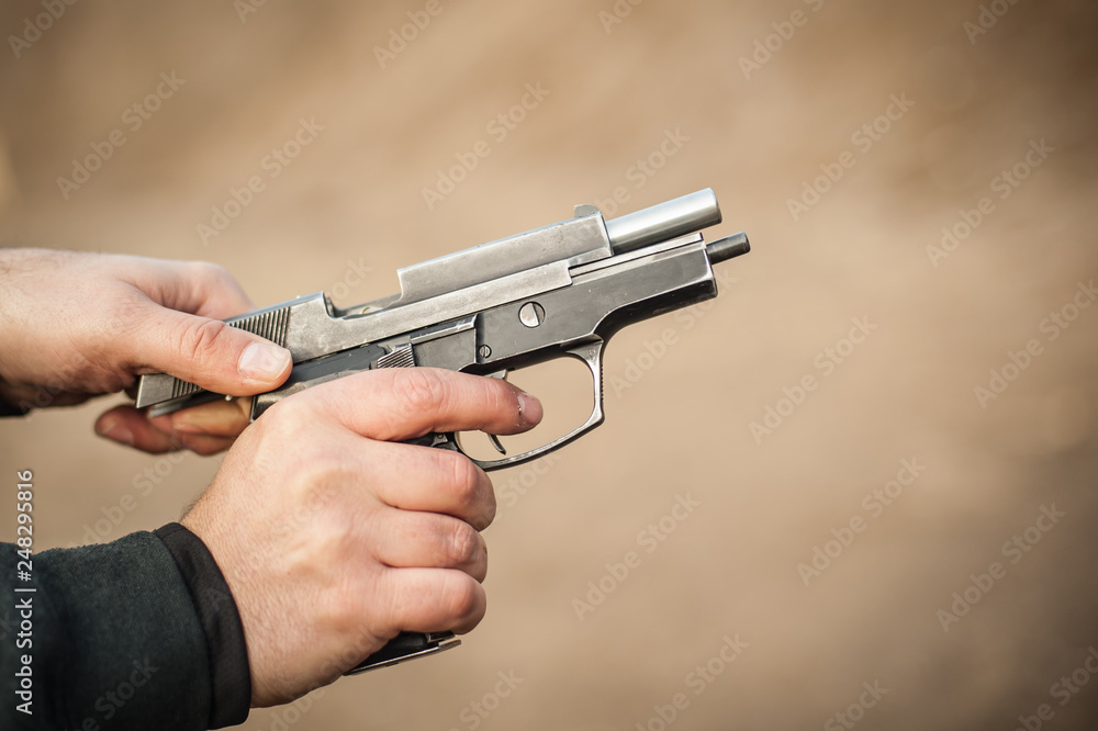 Rack pistol slide. Racking handgun. Pulling back and reloading gun