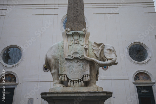 Tourists seated on the Elephant and Obelisk sculpture in Piazza della Minerva in Rome photo