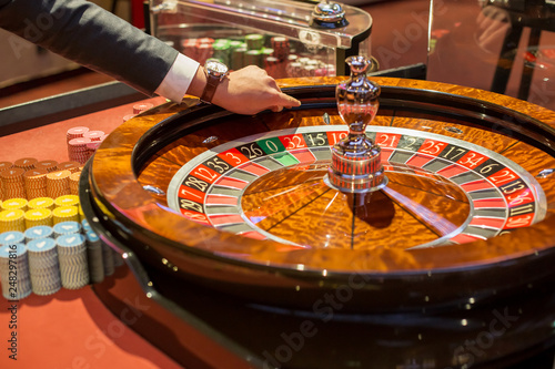 Close up dealer hand starts the ball in Casino gaming table. Poker game in Casino.