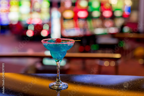 Blue cocktail with cherry on top stands on the bar in the casino.