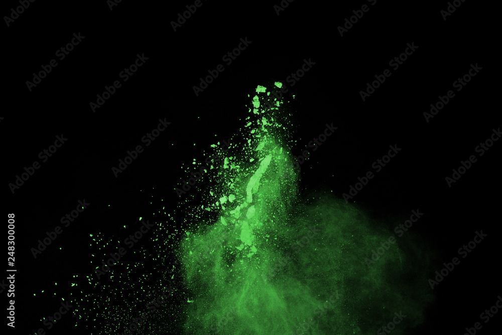 Fototapeta premium The movement of abstract dust explosion frozen green on black background. Stop the movement of powdered green on black background. Explosive powder green on black background.