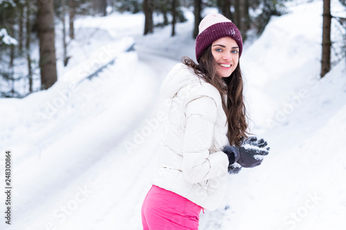 Beautiful woman is playing with snow.