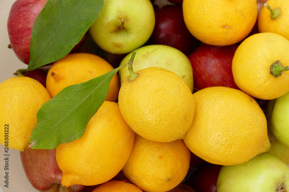 lemon on a leaf, a large amount of natural lemon in a container, yellow lemons,