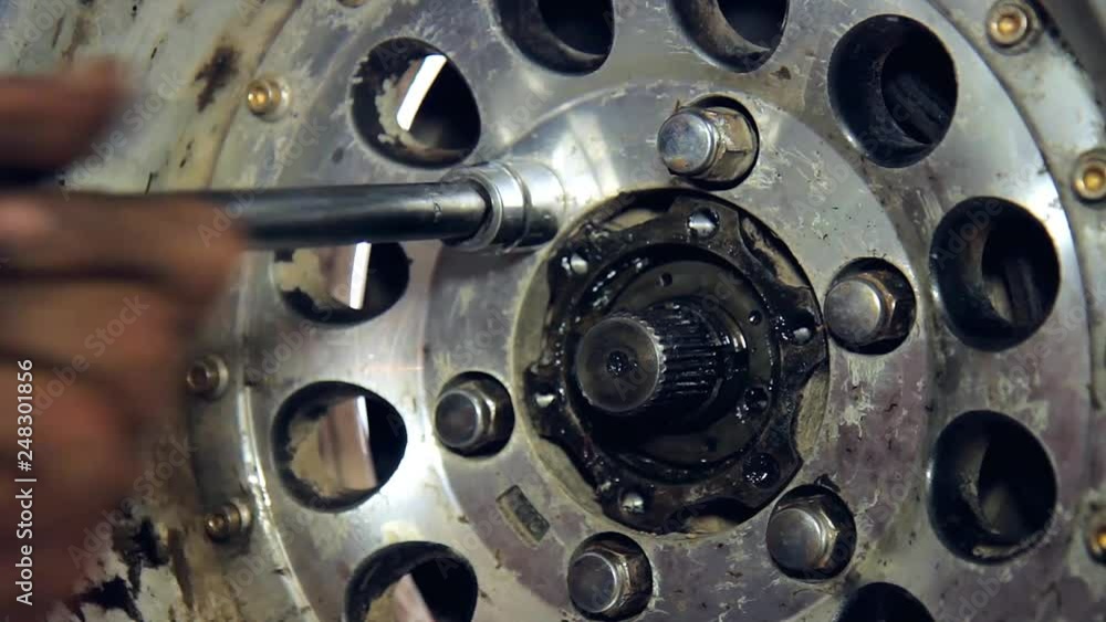 the mechanic tightens the bolts in the wheel the mechanic tightens the bolts in the wheel