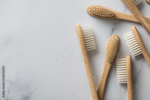 Wooden bamboo toothbrushs on a marble background