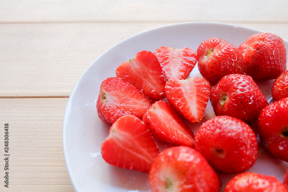 Close up and top view: Fresh and juicy of many sweet red strawberry in white plate on wooden background. Close up and top view: Fresh and juicy of many sweet red strawberry in white plate on wooden background.