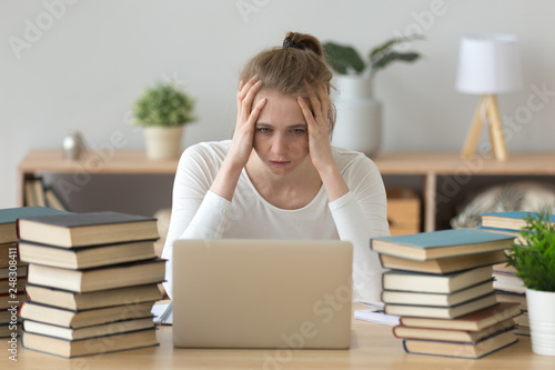 Fotografia Stressed college student tired of hard learning with books laptop