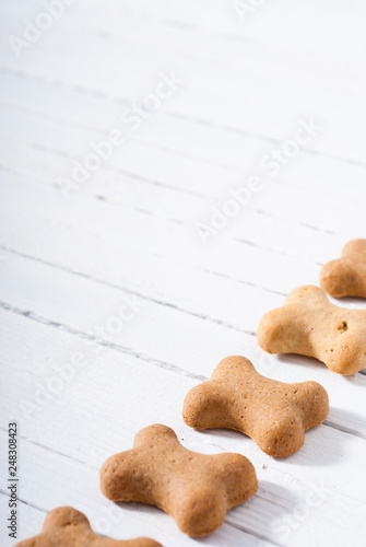 bone shape dog biscuits on white wood background