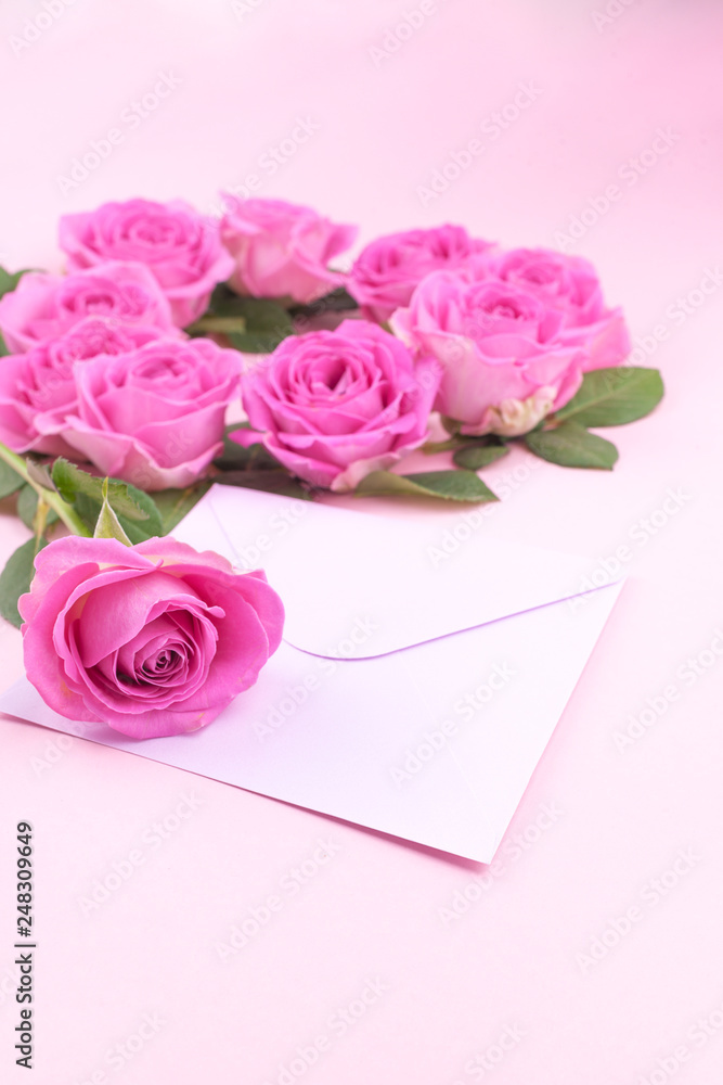 roses and envelope on a light background. Bouquet and letter as a gift in the concept of Valentine's Day or birthday. Free space for text.