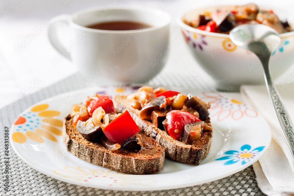 Vegetable stew with eggplant, red pepper and tomatoes on toasted rye bread Vegetable stew with eggplant, red pepper and tomatoes on toasted rye bread
