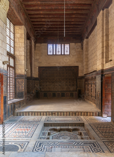 Hall at ottoman era historic house of Moustafa Gaafar Al Seleehdar located at Al Darb Al Asfar District, Cairo, Egypt with decorated wooden ceiling, marble decorated floor and ornate stone walls photo