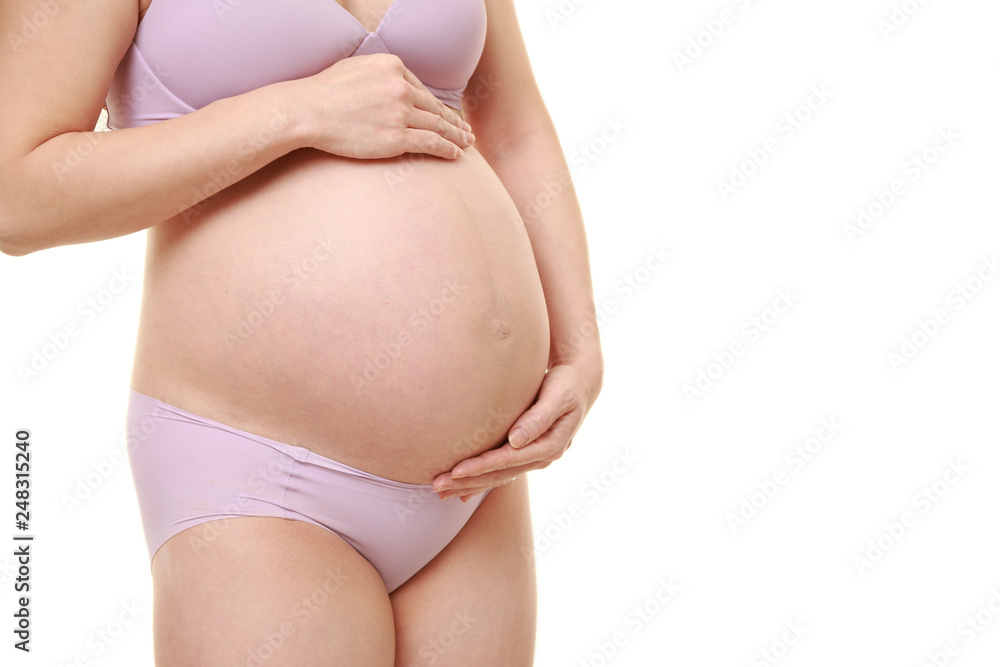 お腹を触る薄紫色の下着を着た臨月の妊婦 お腹を触る薄紫色の下着を着た臨月の妊婦