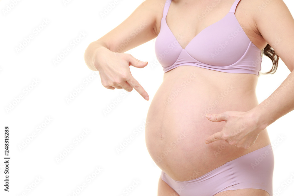 お腹を指差す薄紫色の下着を着た臨月の妊婦 お腹を指差す薄紫色の下着を着た臨月の妊婦