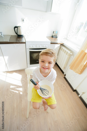 Preschool kid, help mother  making pancakes in the morning, 