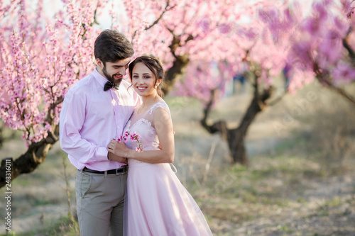 Beautiful wedding couple in the gardens of a blossoming peach.