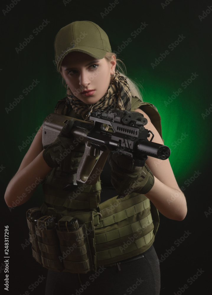 the girl in military special clothes posing with a gun in his hands on a dark background in the haze the girl in military special clothes posing with a gun in his hands on a dark background in the haze