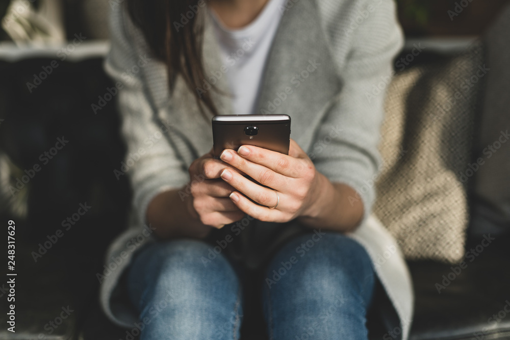 Woman writing text message using her modern cellular Woman writing text message using her modern cellular