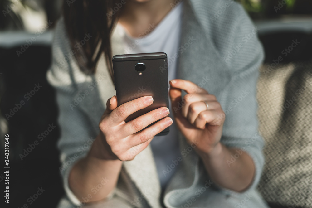 Woman holding cellular in hands and indicate forefinger on display Woman holding cellular in hands and indicate forefinger on display