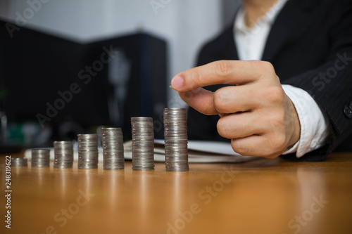 Businessman picks coins on the table, counts money . Business concept.