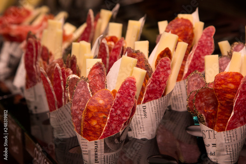 Appetizer of sausage and cheese in a bagel from the newspaper in the market Boqueria in Barcelona