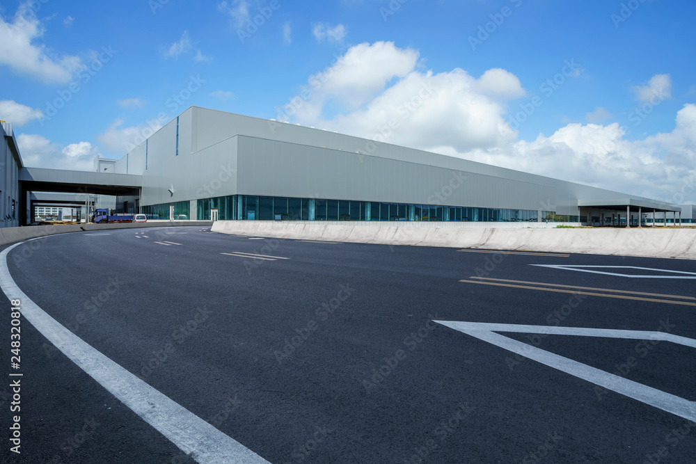 Road asphalt pavement and modern factory warehouse..