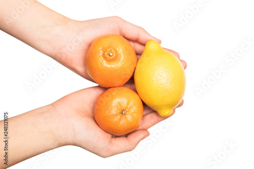 Young girl holds in her hands tangerines and lemon - a concept of healthy food