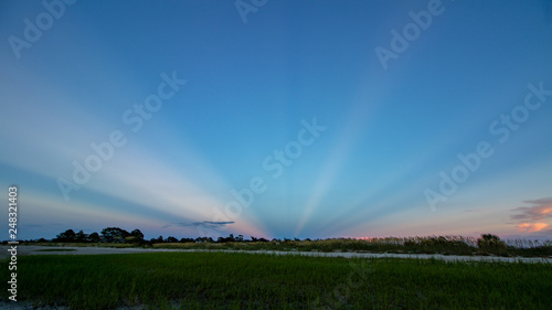 Canvas Print Anticripuscular rays at sunset over beach and sea oats