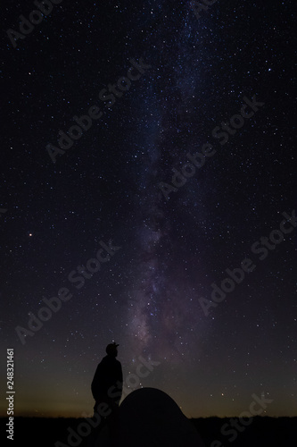 Hiker with tent gazing at milky way