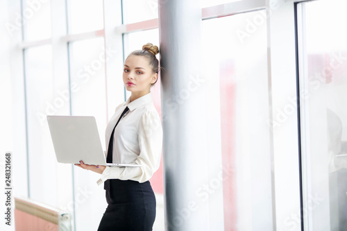 Business woman in blouse and skirt makes entries in a notebook at office center.