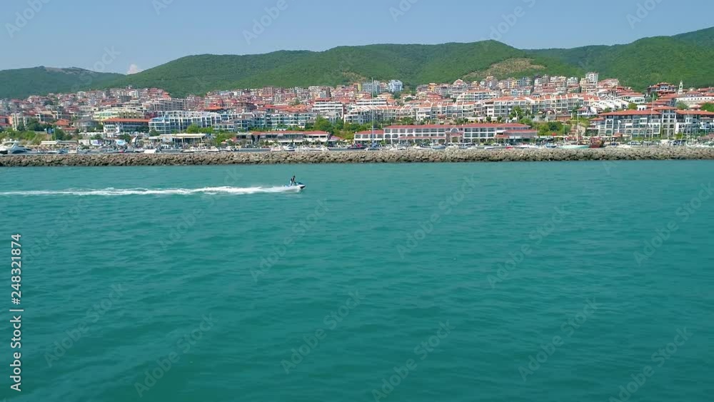 Jet Going Fast in a Distance with a Seashore Village in the Background Jet Going Fast in a Distance with a Seashore Village in the Background