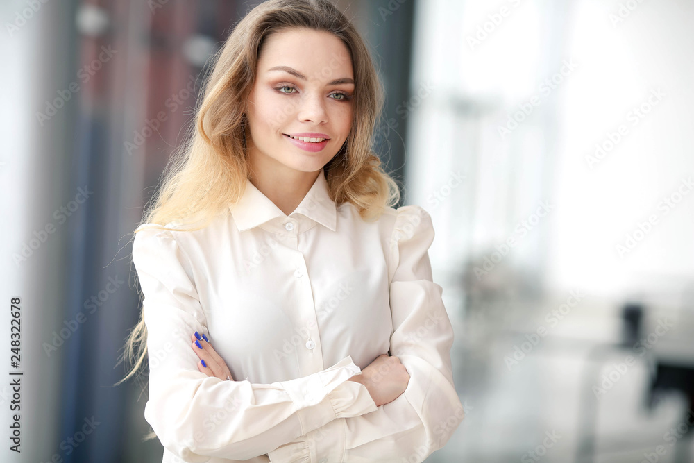 Portrait of a blonde in a white shirt in the business center.