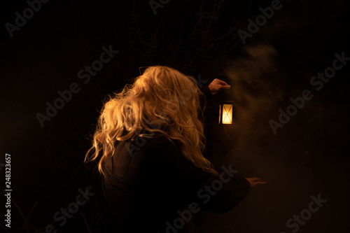 Silhouette of a woman holding lantern in the night. scary scene