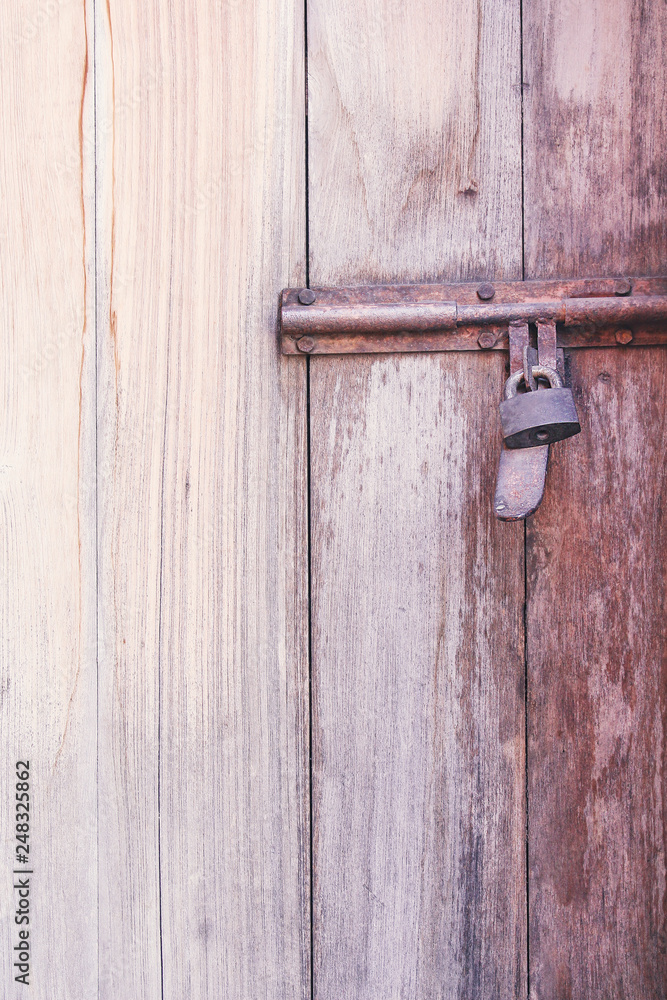 Old rusty steel latch with locked on wood door brown background Old rusty steel latch with locked on wood door brown background