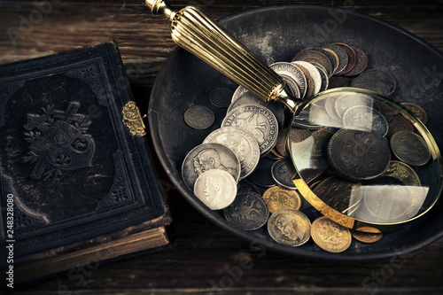 Old moneys and coins through a magnifying glass. Numismatics and collecting money.Russian Empire and world currency.Silver,gold.The Book of Law