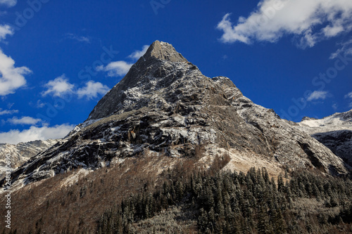 Picturesque winter scenery - Four Girls Mountain National Park in Sichuan Province, China. Shuangqiao Valley, Blue Sky, white puffy clouds, Snow Capped Mountains. Snow Covered Trees, Siguniangshan photo