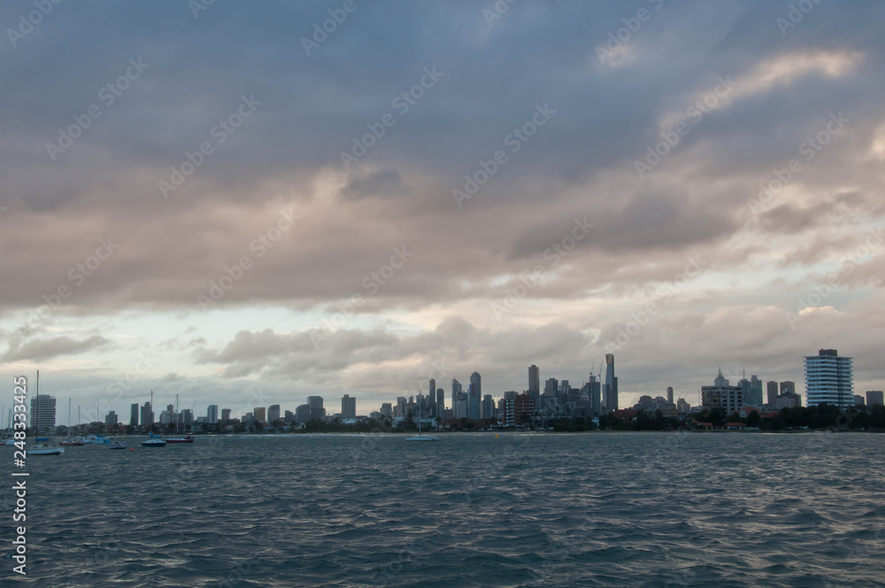 Wide angle evening scene of skyscrapers horizon with ocean and tall office and residential towers in Melbourne Australia